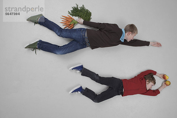 Jungen fliegen mit Obst und Gemüse