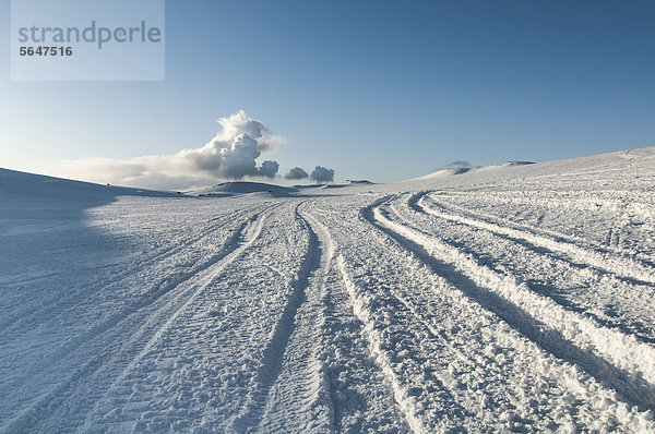 Fahrspuren und Rauchwolke oder Aschewolke vom Vulkan Fimmvör_uh·ls  Fimmvörduhals  zwischen M_rdalsjökull und Eyjafjallajökull  Gletscher M_rdalsjökull  Island  Europa