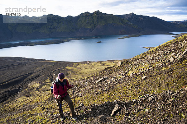 Wanderin besteigt den Berg Sveinstindur  Blick auf den See LangisjÛr  Hochland  Island  Europa