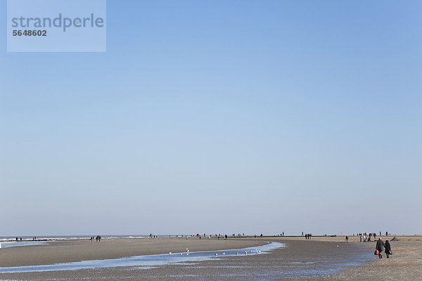 Belgien  Flandern  Menschen  die am Strand spazieren gehen