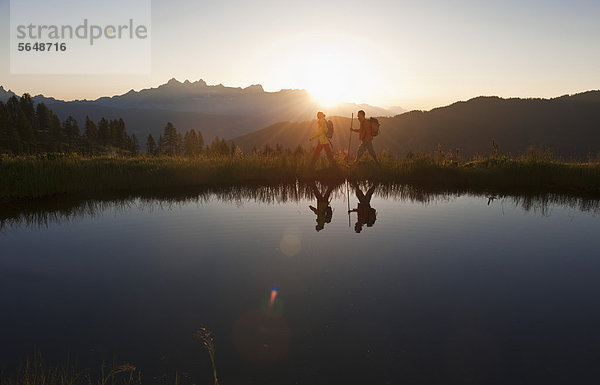 Österreich  Salzburg  Paarwandern am Bergsee bei Sonnenaufgang