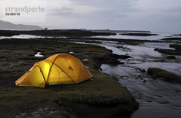 Gelbes erleuchtetes Expeditionszelt  Trekkingzelt  an einer Flussmündung  Abendstimmung  Isle of Skye  Schottland  Großbritannien  Europa