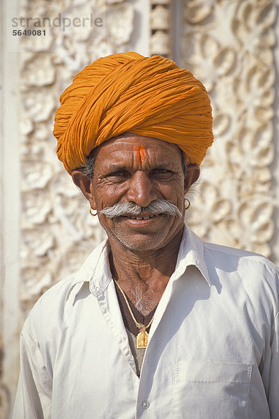 Portrait  Mann mit orangefarbenem Turban  Hindu  vor Marmorfassade Karni-Mata-Tempel  Rattentempel Deshnook oder Deshnok  Rajasthan  Indien  Asien