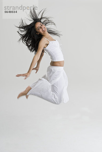 Junge Frau springend und tanzend  lächelnd  Portrait