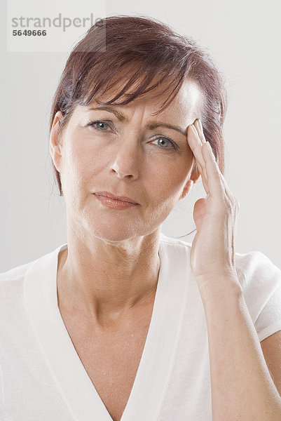 Reife Frau mit Kopfschmerzen  Nahaufnahme