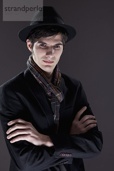 Junger Mann im schwarzen Anzug mit Hut