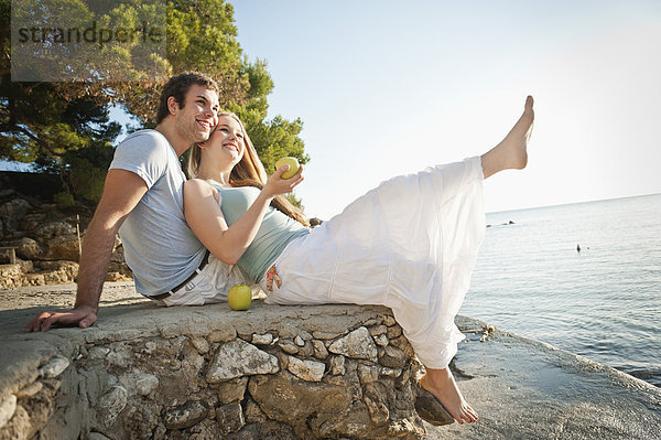 Spanien  Mallorca  Paar am Strand sitzend  lächelnd