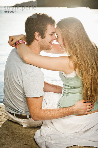 Spanien  Mallorca  Paar am Strand sitzend  lächelnd