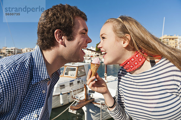 Spanien  Mallorca  Pärchen essen Eis im Hafen  lächeln