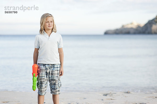 Spanien  Mallorca  Junge mit Wasserpistole am Strand