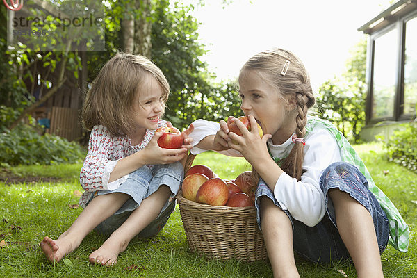 Mädchen essen Apfel im Garten