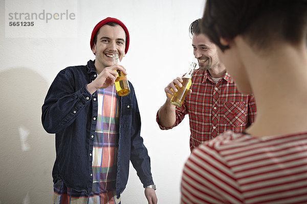 Männer und Frauen  die Bier trinken  lächelnd