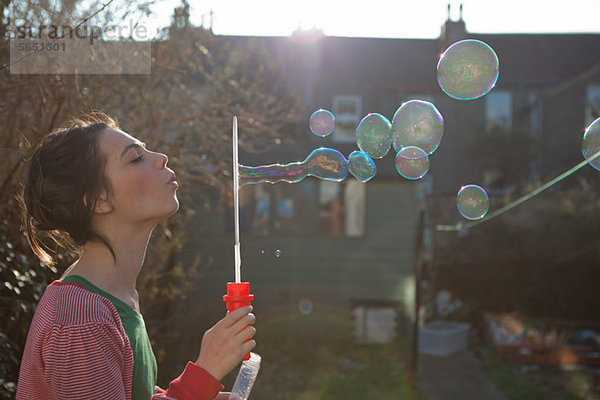 Junge Frau bläst Blasen im Freien