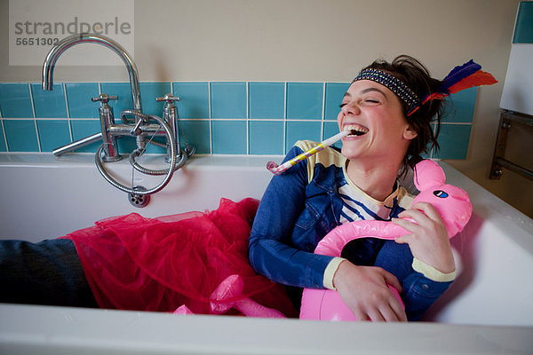 Junge Frau im Bad  in Kostüm und Blasen Partygebläse