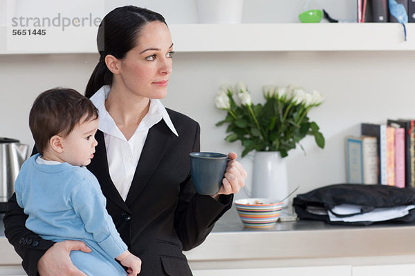 Geschäftsfrau mit Baby-Sohn und Kaffeetasse