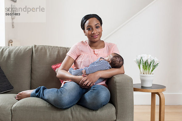 Junge Frau auf Sofa mit Baby-Sohn