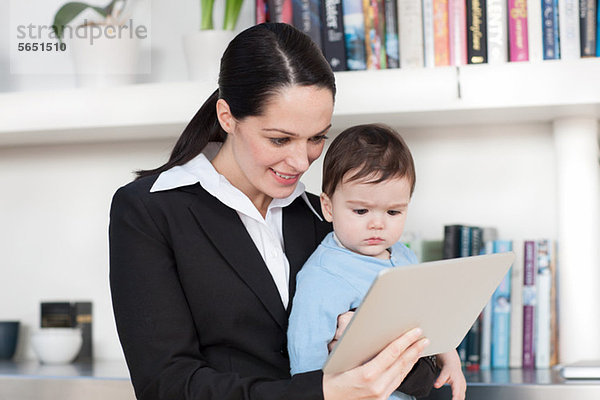 Geschäftsfrau Mutter und Baby beim Betrachten des digitalen Tabletts