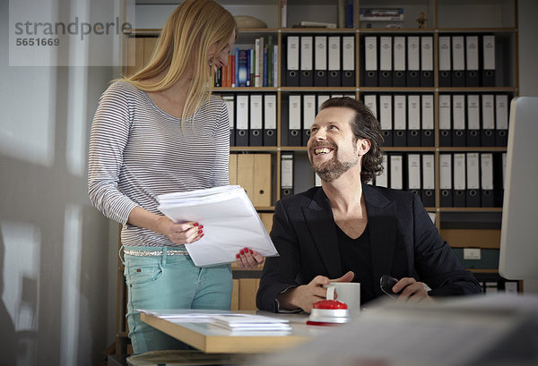 Mann und Frau  die im Büro arbeiten  lächelnd