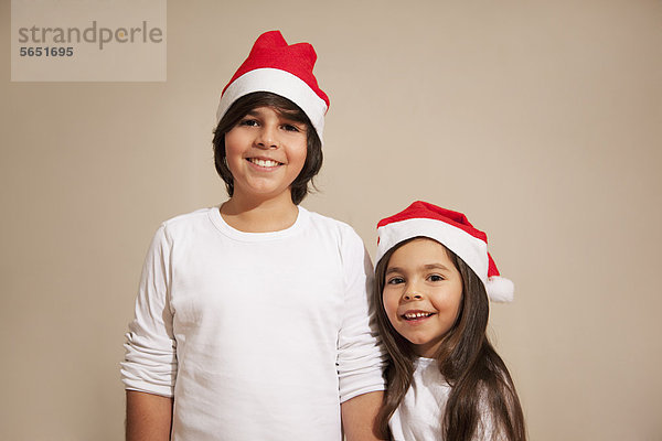 Kinder mit Weihnachtsmütze  lächelnd  Portrait
