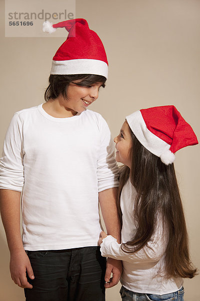 Kinder mit Weihnachtsmütze  lächelnd