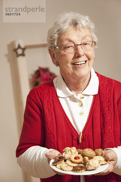 Seniorin mit Weihnachtsplätzchen  lächelnd  Portrait