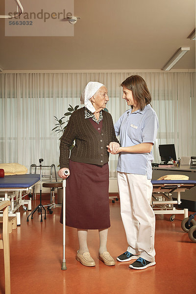 Alte Frau mit Pflegerin bei der Physiotherapie im Pflegeheim