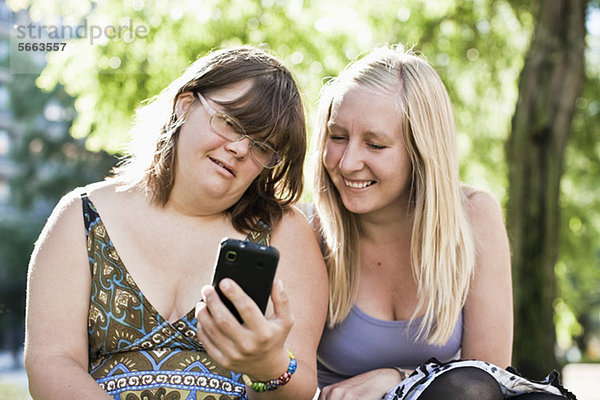 Junge Frau mit Down-Syndrom ihre persönliche Assistentin beim gemeinsamen Telefonieren