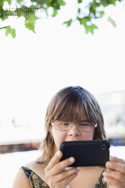 Cute Frau mit Down-Syndrom klicken Foto auf dem Handy