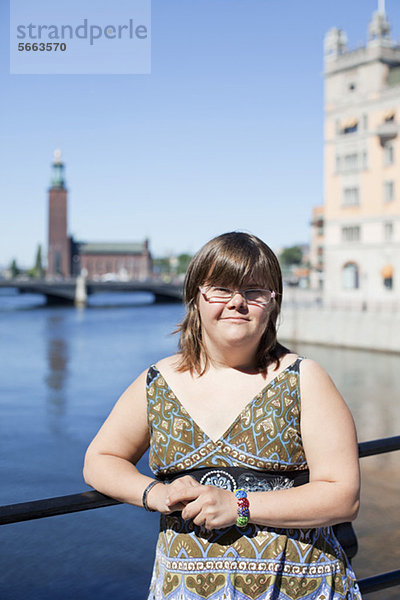Porträt einer unschuldigen Frau mit Down-Syndrom  die im Freien lächelt.