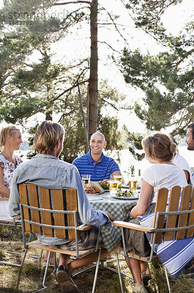 Gruppe von Freunden beim gemeinsamen Essen im Freien