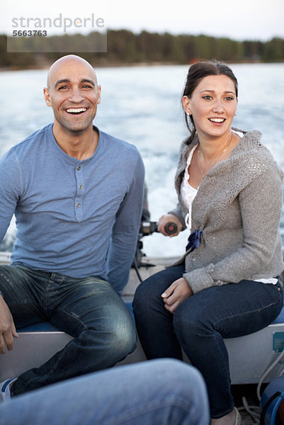 Fröhlicher Mann mit Frau beim Motorbootfahren