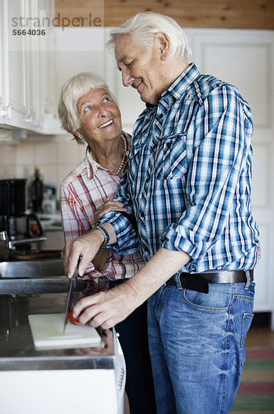 Glückliches Seniorenpaar beim gemeinsamen Kochen