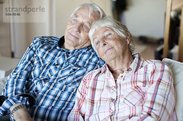 Seniorenpaar entspannt sich gemeinsam auf dem Sofa im Wohnen