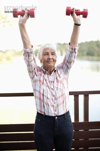 Aktive Seniorenfrau beim Heben von Handgewicht beim Sport