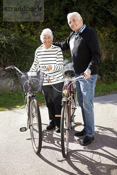 Portrait eines aktiven Seniorenpaares  das zusammen mit Fahrrädern steht