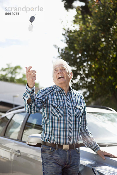 Senior Mann wirft Autoschlüssel in die Luft