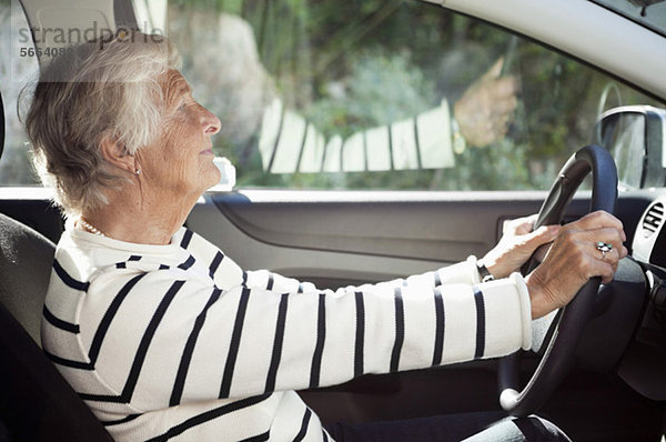 Seitenansicht der Seniorin auf dem Fahrersitz im Auto
