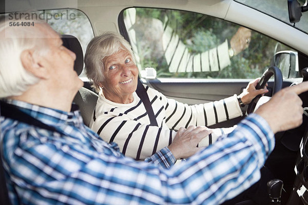Aktives Seniorenpaar lächelt im Auto