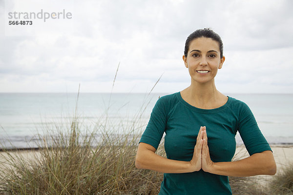 Reife Frau beim Yoga am Strand  Portrait