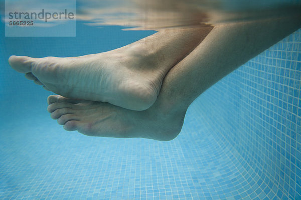 Männerbeine im Wasser  Unterwasseransicht