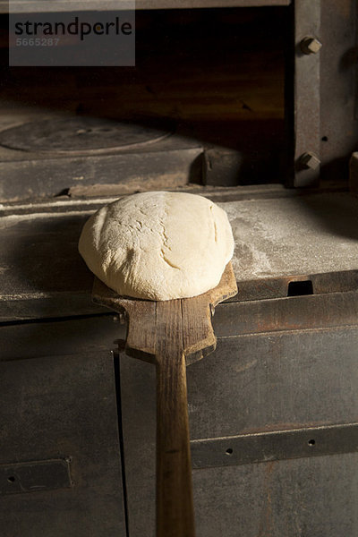 Ungebackenes Brot in den Ofen stellen