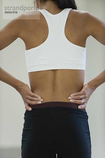 Frau mit Rückenschmerzen  Rückansicht