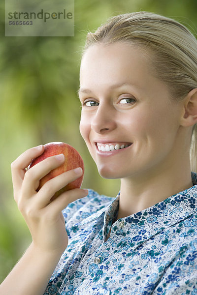 Lächelnde junge Frau mit Apfel  Portrait