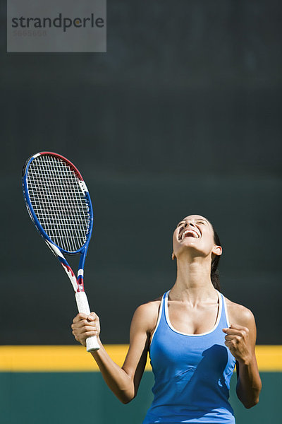 Jubelnde junge Tennisspielerin  Portrait