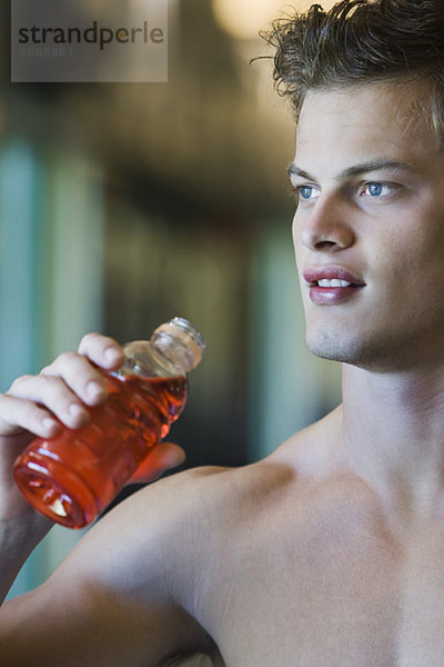 Barechested junger Mann hält Flasche Sportgetränk  abgeschnitten