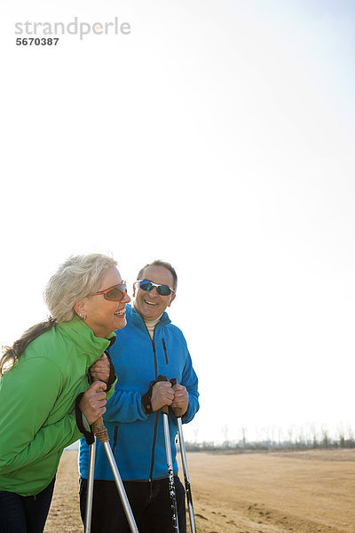 Lächelndes Paar macht Nordic Walking