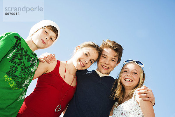Vier fröhliche Teenager-Freunde im Freien