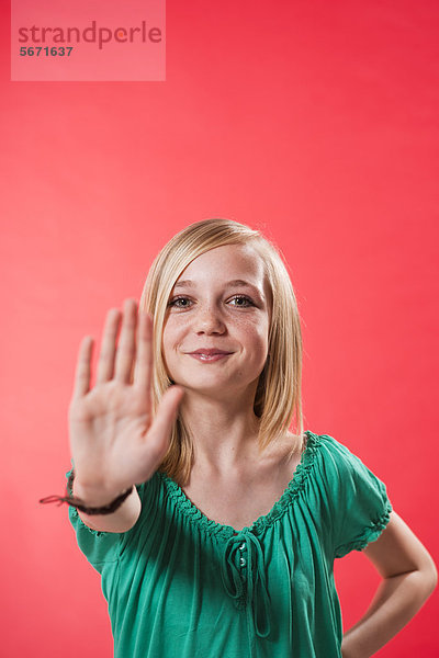 Teenagerin hebt ihre Hand zur Abwehr