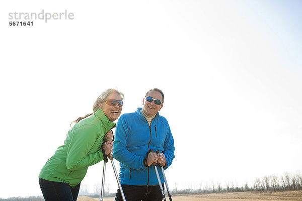Fröhliches Paar macht Nordic Walking