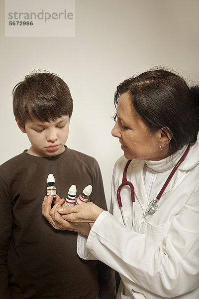 Junge bekommt Globuli von Homöopathin